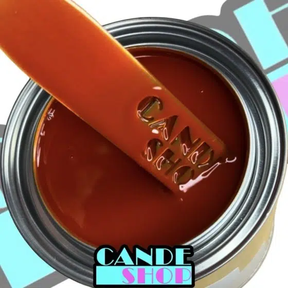unreduced atomic tango cande in a quart can with a stainless steel mixing stick being pulled out to show the tangerine orange transparent color