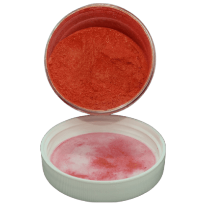 peach gold pearl powder in jar spilling onto lid